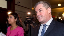 O ministro da Educação do Quebec, Yves Bolduc, à direita, sai de uma reunião do «caucus» do governo - 25 de fevereiro, 2015 - na legislatura em Quebec City. (THE Canadian Press / Jacques Boissinot)