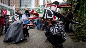 Gary Humchitt, à direita, da primeira nação Kwakiutl, em Fort Rupert, B.C., e Shawn Edenshaw, à esquerda, da Primeira Nação Haida, usam esculturas tradicionais nas suas cabeças, enquanto aguardam para participar na Caminhada para a Reconciliação em Vancouver, B.C., - 22 de setembro de 2013. The Canadian Press / Darryl Dyck