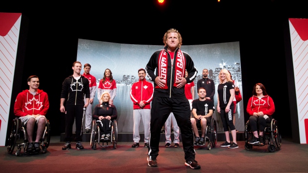 O atleta olímpico Kurt Harnett, centro, e atletas canadianos vestem os uniformes oficiais da equipa, da Hudson Bay, para os Jogos Pan/Parapan-americanos em Toronto - 28 de abril de 2015. (The Canadian Press / Nathan Denette)