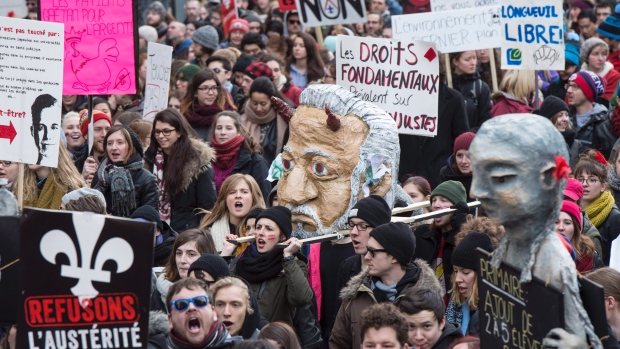 Os alunos carregam uma cabeça falsa do primeiro-ministro do Quebec, Philippe Couillard, durante uma manifestação contra medidas de austeridade e cortes do governo, num protesto realizado na quinta-feira, 2 de abril em Montreal. (Paul Chiasson / The Canadian Press)