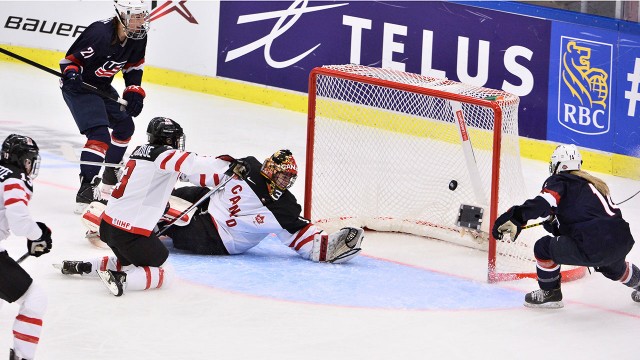 Brianna Decker dos EUA, à direita, marca o sexto golo da sua equipa frente à guarda-redes do Canadá, Genevieve Lacasse, durante a final do Campeonato do mundo feminino IIHF 2015. (Claudio Bresciani / AP)