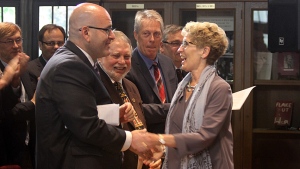 A primeira-ministra Kathleen Wynne aperta as mãos do ministro dos Transportes Steven Del Duca, deputado provincial Ted McMeekin e presidente Fred Eisenberger, durante o anúncio de mil milhões de dólares para o LRT em Hamilton na terça-feira. (Samantha Craggs / CBC)