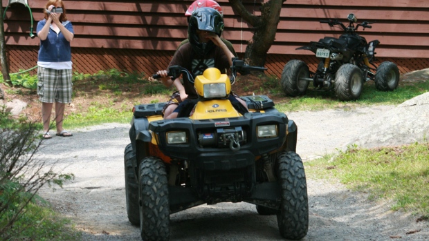 Um adolescente monta um ATV (All Terrain Vehicle) numa casa de campo em Coon Lake perto de Lakefield, Ontário, nesta foto de arquivo. (Richard Buchan / The Canadian Press)