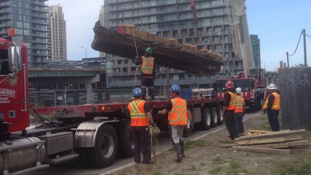 Os restos de escuna incompletos foram cuidadosamente levantados por um guindaste e carregados num camião para serem levados para o Fort York. (Kira Wakeam / CBC)