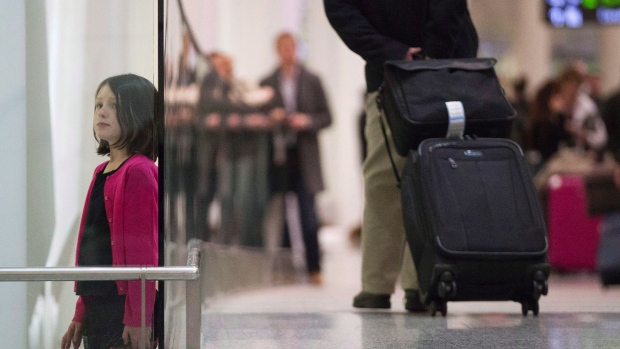 A jovem Ava Diamond de sete anos de idade observa os viajantes a chegar ao Aeroporto International Pearson de Toronto, nesta foto de arquivo. (Chris Young / The Canadian Press)