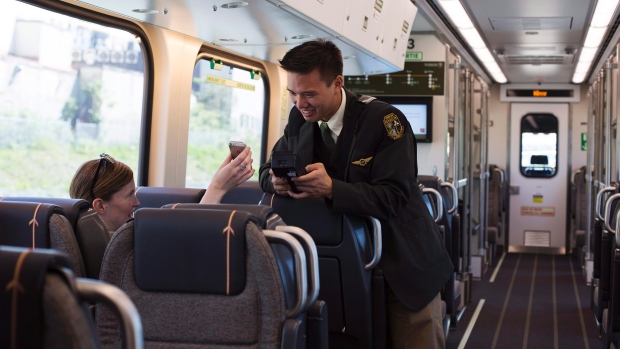 Um passageiro vê o seu bilhete digitalizado durante a nova ligação ferroviária do expresso da estação Union para o aeroporto Pearson de Toronto - 6 de junho de 2015. The Canadian Press / Michelle Siu