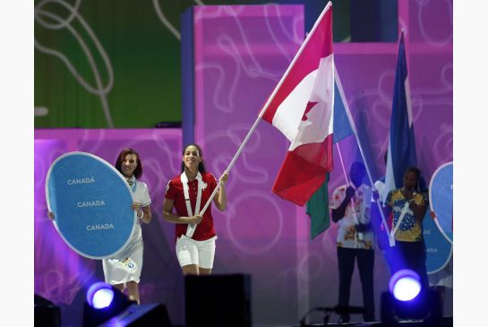 A jogadora de basquetebol Kia Nurse transporta a bandeira do Canadá, durante o desfile das nações na cerimónia de encerramento dos Jogos Pan-Americanos, no domingo (Julio Cortez / The Associated Press)