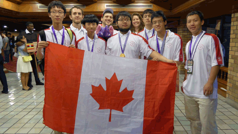 Jinhao (Hunter) Xu, James Rickards (Observador), Kevin Sun, Jacob Tsimerman (Líder), Zhuo Qun (Alex) Song, Lindsey Shorser (vice-líder), Alexander Whatley, Michael Pang e Yan (Bill) Huang são mostrados na Olimpíada Internacional de Matemática na Tailândia em 16 de julho de 2015. CANADIAN MATHEMATICAL SOCIETY