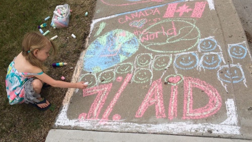 Uma menina de Regina desenha no passeio com giz em apoio à campanha #ChalkYourSidewalk. (Millennium Kids / Tumblr)