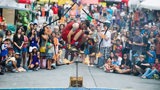 Brant Matthews, aka The Fire Guy salta através de um aro em chamas com o seu skate durante o dia de abertura do Scotiabank Buskerfest em Toronto - 25 de agosto de 2011. The Canadian Press/Aaron Vincent Elkaim