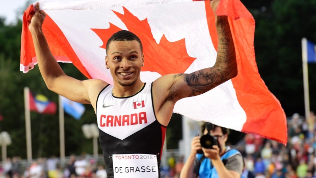 Andre De Grasse, do Canadá, segura uma bandeira depois de vencer a medalha de ouro na final masculina de 100m, durante a competição de atletismo nos Jogos Pan Am 2015 em Toronto - 22 de julho de 2015. (The Canadian Press / Frank Gunn)