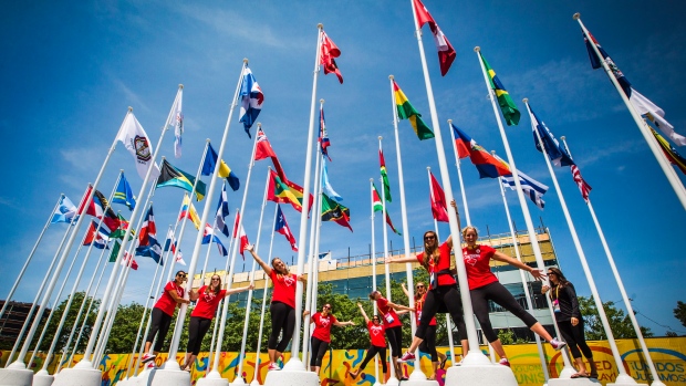 A equipa de pólo aquático feminino do Canadá posa para uma foto nos mastros de bandeira dentro da aldeia dos atletas dos Jogos Pan-Americanos em Toronto - 3 de julho de 2015. (Mark Blinch / The Canadian Press)