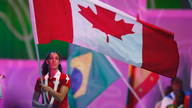 A portadora da bandeira do Canadá, membro da equipa de basquetebol feminino Kia Nurse, carrega a bandeira canadiana durante as cerimónias de encerramento dos Toronto 2015 Pan Am Games em Toronto, Ontário - 26 de julho de 2015. (Mark Blinch / The Canadian Press)