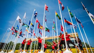 A equipa de pólo aquático feminina canadiana posa para uma fotografia nos mastros de bandeira dentro da aldeia dos atletas para os Jogos Pan-Americanos em Toronto - 3 de julho de 2015. (Mark Blinch / The Canadian Press)