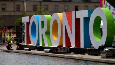 Trabalhadores erguem letras gigantes que soletram a palavra Toronto na Nathan Phillips Square, enquanto se preparam para os Jogos Pan-americanos - 8 de julho de 2015. (AP / Rebecca Blackwell)