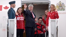 O primeiro-ministro Stephen Harper, centro, acompanhado pelos atletas canadianos Pan Am e Parapan Am Elise Marcotte, segunda a partir da esquerda, Marco Dispaltro, terceiro da direita, Priscilla Gagne, segunda a partir da direita, e Tera Van Beilen, à direita, acena antes da partida para o Panamá para participar na Cimeira das Américas, em Otava - 10 de abril de 2015. (Adrian Wyld / The Canadian Press)