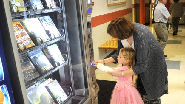 Veronica O'Brien, de cinco anos de idade, à esquerda, com a ajuda da Diretora-Executiva da Biblioteca Pública da área de Bethlehem Janet Fricker, seleciona um livro num quiosque biblioteca instalado em Hanover Township, Pa., - 22 de maio de 2012. (Express-Times , Lisa Massey)