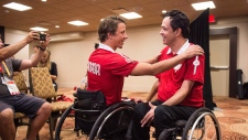 O atleta embaixador para os Parapan Am Games Josh Dueck, à esquerda, apresenta o jogador de boccia Marco Dispaltro como o porta-bandeira para a equipa do Canadá durante uma conferência de imprensa em Toronto na quarta-feira 5 de agosto, 2015. (Aaron Vincent Elkaim / The Canadian Press)