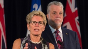 A primeira-ministra do Ontário Kathleen Wynne fala numa conferência de imprensa, com o primeiro-ministro do Quebec Philippe Couillard, à direita, no início de uma reunião conjunta entre o Ontário e o Quebec em Quebec City (setembro 2015). (The Canadian Press / Jacques Boissinot)