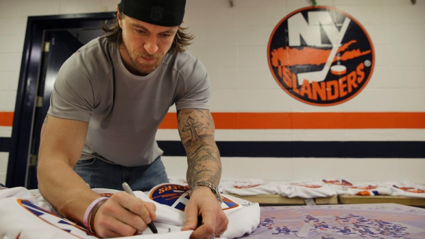 Michael Grabner dos New York Islanders assina memorabilia no Nassau Coliseum em Uniondale, Nova Iorque -28 de abril de 2015. (AP Photo / Seth Wenig)