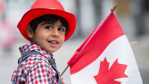 Sam Kashfi, de três anos de idade, sorri durante o desfile anual do dia do Canadá em Montreal, 1 de julho de 2015. (Graham Hughes / The Canadian Press)