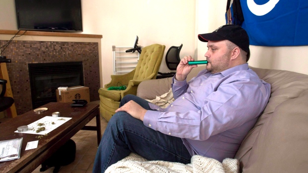 Clayton Goodwin inala a marijuana medicinal através de um vaporizador no seu apartamento em Otava - 20 de março de 2015. The Canadian Press/Adrian Wyld