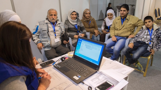 Uma família de refugiados sírios é entrevistada por autoridades num centro de tratamento de processos de refugiados em Amã, na Jordânia, na esperança de obter autorização para viajar para o Canadá, - 29 de novembro de 2015. The Canadian Press / Paul Chiasson