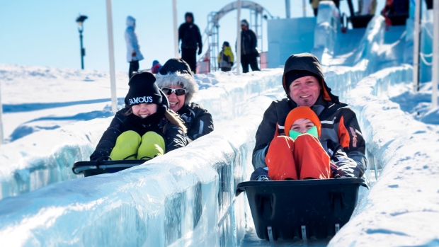 Festivaleiros deslizam num escorrega de gelo no Carnaval do Quebec em Quebec City (Carnaval de Quebec)