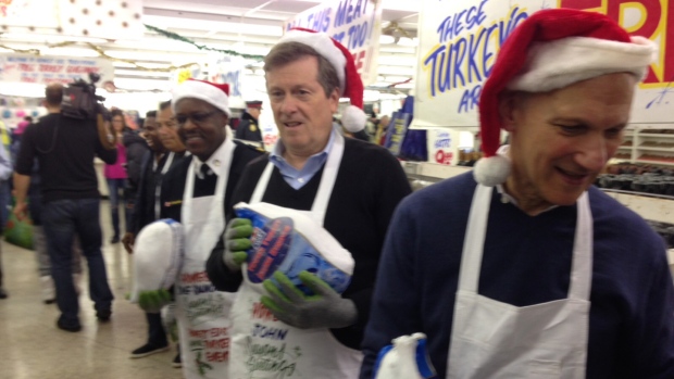 O presidente de Toronto John Tory (centro) participa na última edição de oferta de peru no Honest Ed’s, junto com David Mirvish (direita) e o chefe da polícia Mark Saunders.