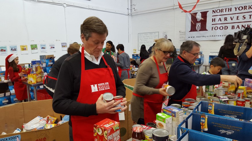 O presidente de Toronto John Tory separa as doações com outros voluntários no North York Harvest Food Bank em 20 de dezembro de 2015. CityNews/Jerome Gange