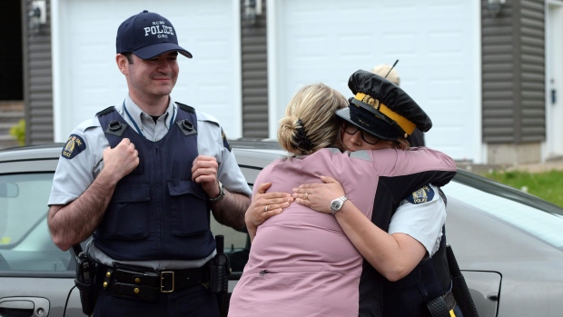 Nesta foto de arquivo (2014), um residente agradece a dois oficiais da Real Polícia Montada Canadiana em Moncton, New Brunswick. (Sean Kilpatrick / The Canadian Press)