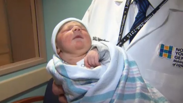 Um doutor segura o bebé Julian no Hospital Geral de North York em Toronto na sexta-feira 1 de janeiro, 2016.