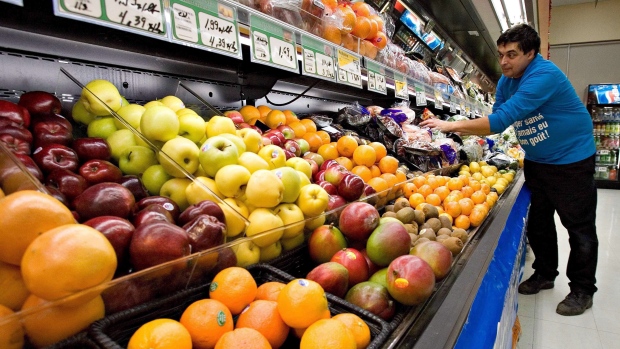 O proprietário de supermercado Gilles Robin prepara a montra de frutas e vegetais em Breakeyville, Que., nesta foto de arquivo. (Jacques Boissinot / The Canadian Press)