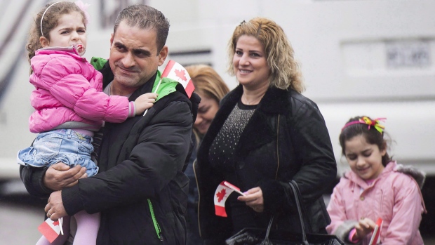 Refugiados sírios recém-chegados encontram-se com patrocinadores e familiares no Armenian Community Centre em Toronto - 16 de dezembro de 2015. The Canadian Press / Nathan Denette