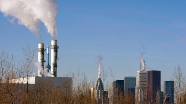 A CN Tower é enquadrada pelas chaminés no Centro de Energia Portlands em Toronto. FOTO: The Canadian Press