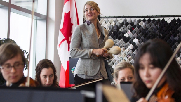 A ministra Federal do Canadá para o Património Melanie Joly junta-se a membros da Orquestra Sinfónica de Toronto, em Toronto, na segunda-feira 14 de março de 2016 (Chris Young/The Canadian Press)