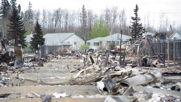 Casas queimadas e outras casas intocadas pelos incêndios em pano de fundo em Fort McMurray, Alta., - 9 de maio de 2016. (The Canadian Press / Jonathan Hayward)