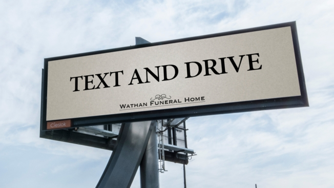 Um outdoor com publicidade à Wathan Funeral Home é na verdade um PSA relacionado com a condução distraída