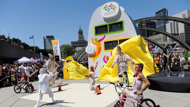 Membros do Cirque du Soleil ajudam a desvendar o relógio de contagem decrescente para os Jogos Pan-Americanos TORONTO 2015 na Nathan Phillips Square em Toronto. 11 de julho, 2014 (divulgação)