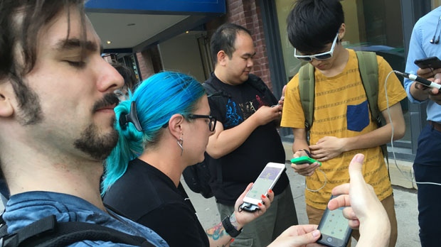 Um grupo joga o Pokemon Go no centro de Toronto. (Josh Freeman / CP24.com)