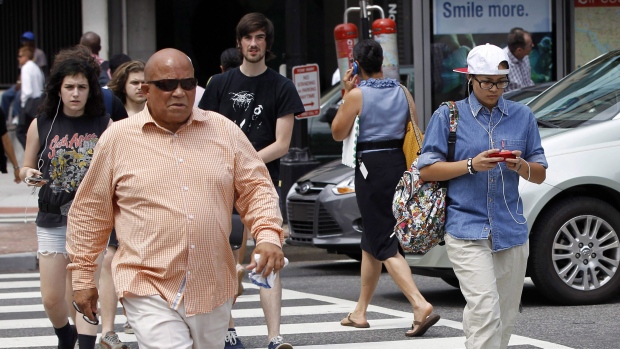 Nesta foto de arquivo de 10 de julho de 2012, um peão escreve um SMS ao atravessar a rua no centro de Washington. (AP Photo / Pablo Martinez Monsivais)