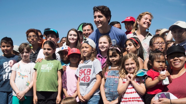 O primeiro-ministro Justin Trudeau e a sua esposa, Sophie Grégoire Trudeau, posam com crianças durante um evento em Toronto no mês passado. (Mark Blinch / Canadian Press)