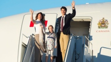 O primeiro-ministro Justin Trudeau, a sua esposa Sophie Gregoire, e a filha Ella-Grace acenam no embarque de um avião do governo em Otava - 29 de agosto de 2016. (The Canadian Press / Adrian Wyld)