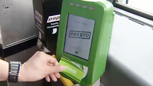 Um passageiro usa um leitor de cartão Presto em Toronto.
