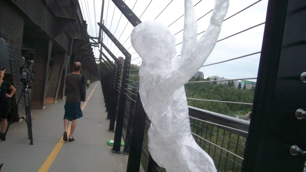 Algumas figuras humanas em tamanho natural feitas de fita de plástico transparente foram anexadas às barreiras de prevenção do suicídio numa ponte de Edmonton no mês passado. O Canadá continua a ser o único país desenvolvido sem uma estratégia nacional de prevenção do suicídio. (Rob Drinkwater/Canadian Press)