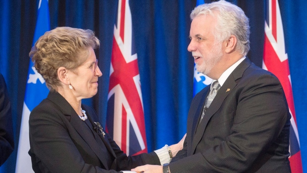 A primeira-ministra do Ontário, Kathleen Wynne, e o primeiro-ministro do Québec, Philippe Couillard, apertam as mãos após a assinatura de um acordo energético em Montreal, na quinta-feira, 15 de dezembro de 2016. THE CANADIAN PRESS / Ryan Remiorz