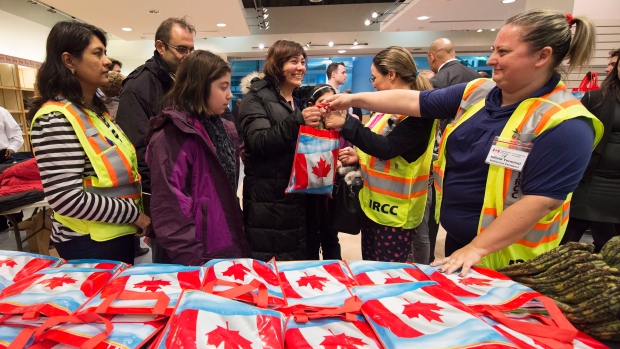 A recém-chegada refugiada síria, Anjilik Jaghlassian, e a sua família recebem roupas de inverno e outros itens no aeroporto internacional Pearson, em Toronto - 11 de dezembro de 2015. (THE CANADIAN PRESS / Nathan Denette)
