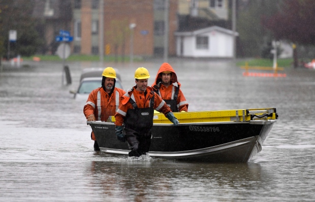 Trabalhadores da Hydro-Québec empurram um barco com equipamentos na Rua Saint-Louis, em Gatineau. (Justin Tang / Canadian Press)