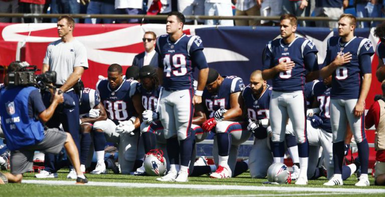 FUTEBOL NORTE-AMERICANO UNE-SE NO DESAFIO A TRUMP E AJOELHA DURANTE O HINO