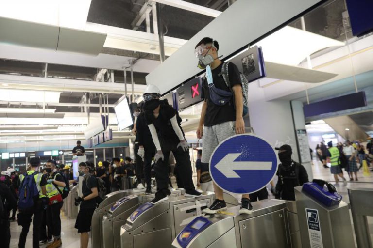 MANIFESTANTES BARRICAM-SE EM ESTAÇÃO DE METRO DE HONG KONG CONTRA POLÍCIA ANTIMOTIM